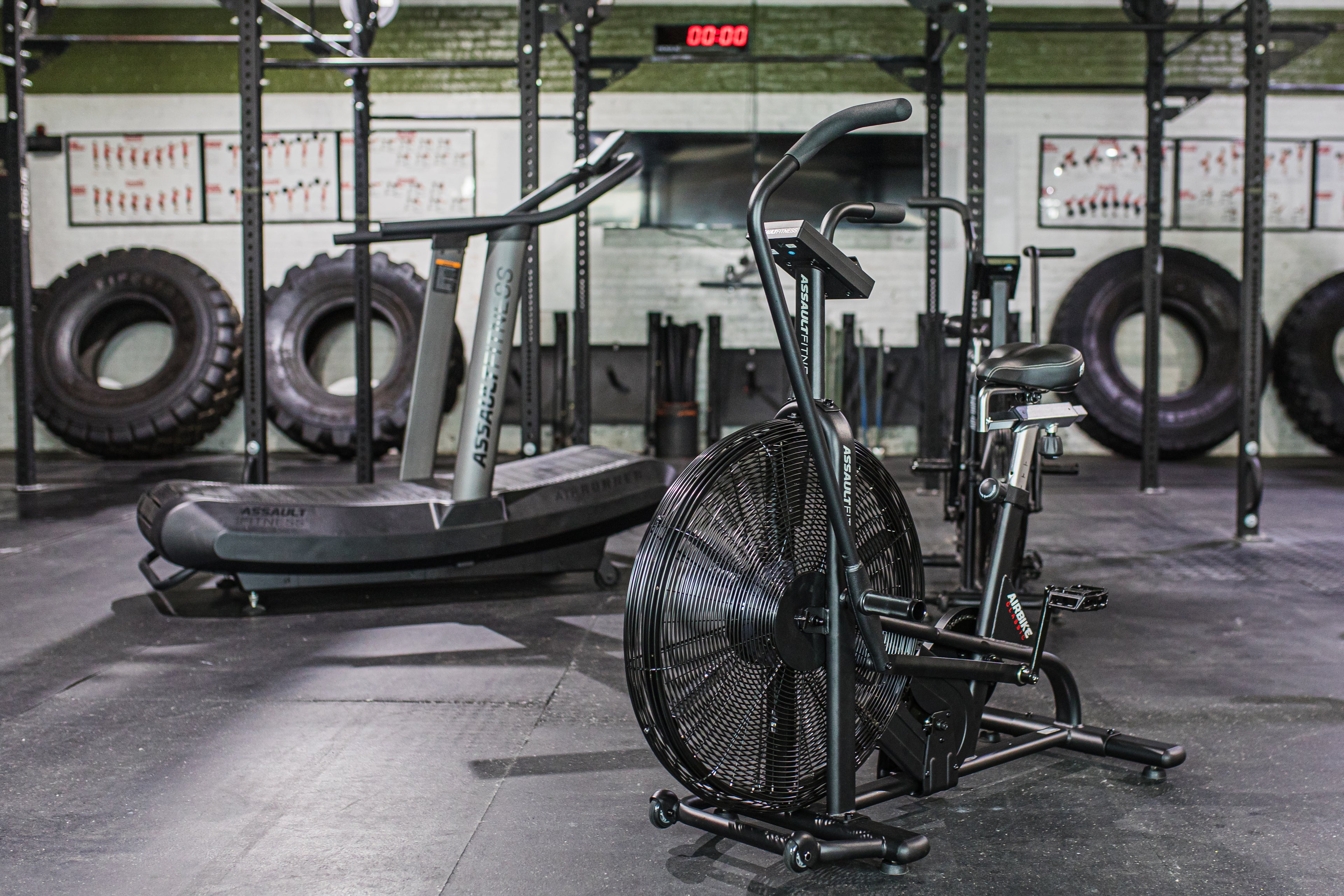 The assaultbike classic and assaultrunner positioned at an angle among other fitness equipment in a gym